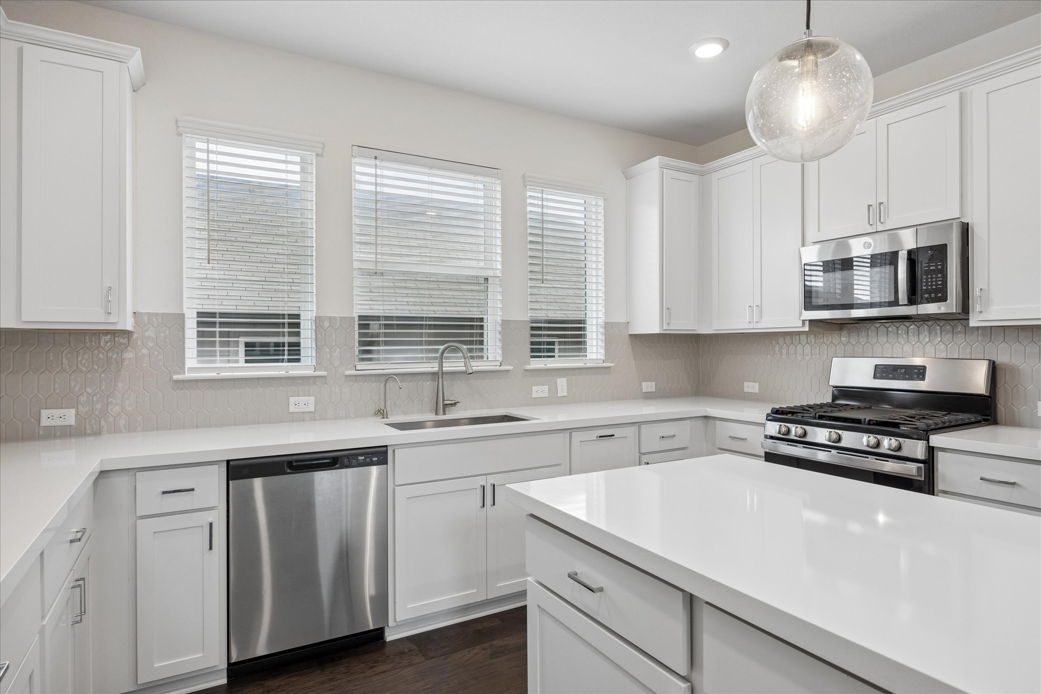 6407 Rounded Pebble Lane Buda, TX 78610 - Photo 10 of 32 A well-equipped kitchen features a generous island, stainless steel appliances, and sleek countertops.