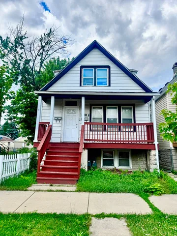 a front view of a house with a yard and potted plants