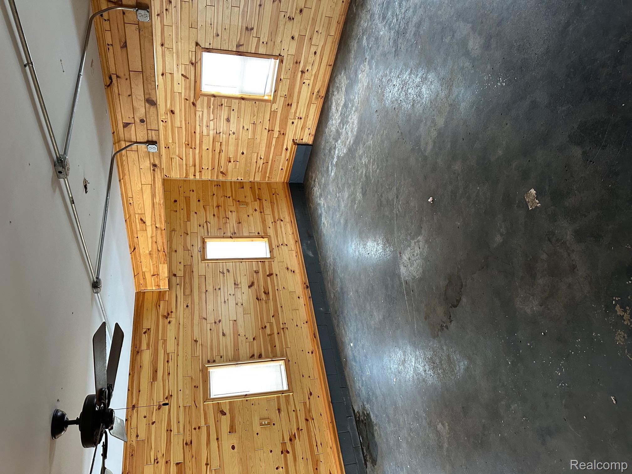 3803 Warner Road Cass City, MI 48726 - Photo 42 of 85 Spare room with concrete floors, wood walls, and plenty of natural light