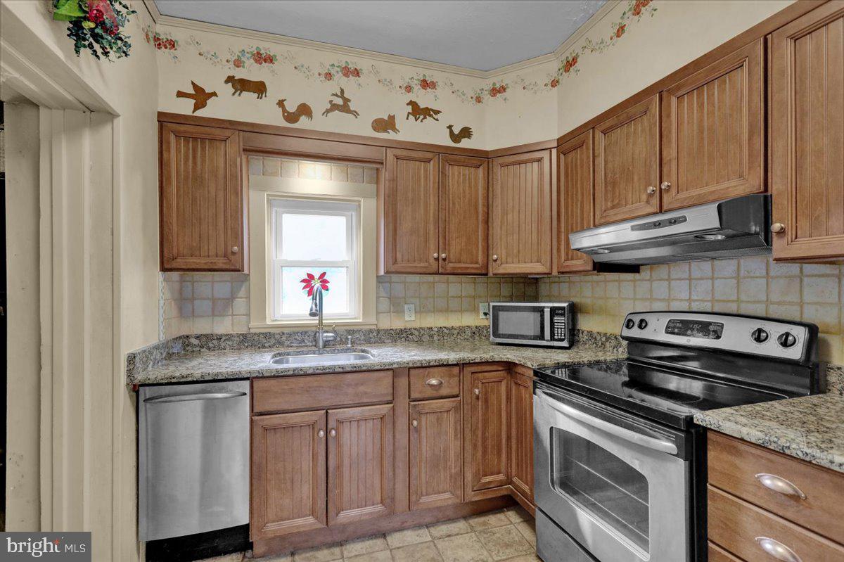 758 Fritztown Road Reading, PA 19608 - Photo 13 of 27 a kitchen with granite countertop a sink stove and cabinets