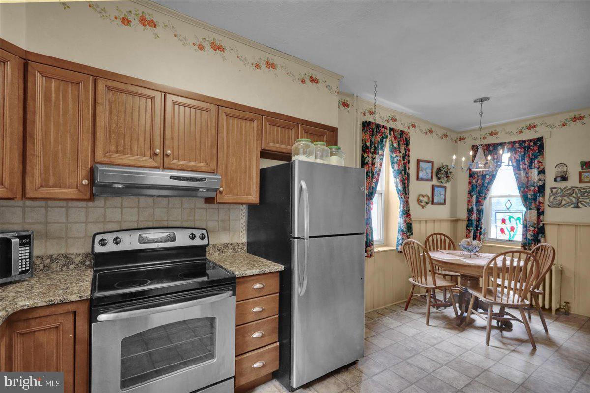 758 Fritztown Road Reading, PA 19608 - Photo 14 of 27 a kitchen with a refrigerator a stove a washer and dryer with wooden floor