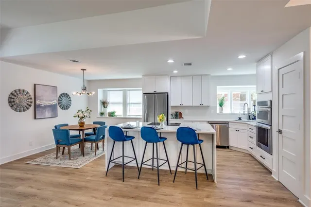 a kitchen with cabinets table and chairs