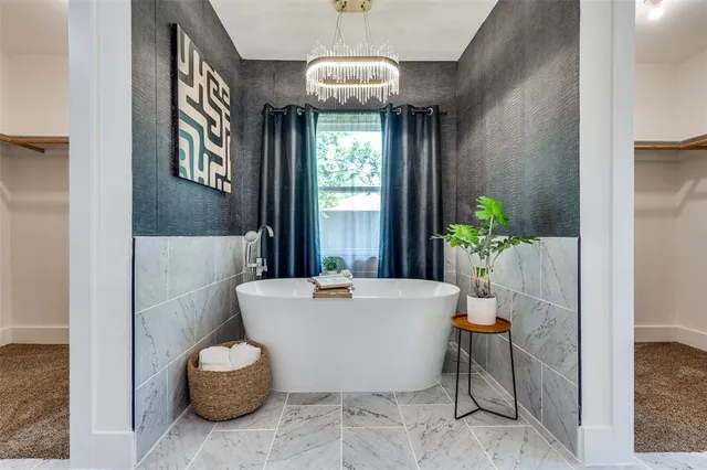 a white bath tub sitting in a bathroom next to a window