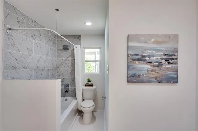 a bathroom with a toilet and a shower