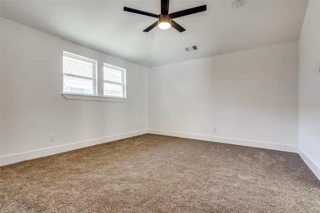an empty room with a ceiling fan and window