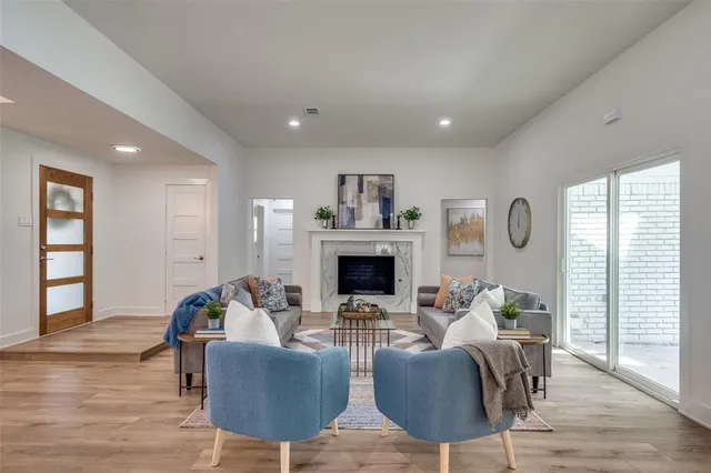 a living room with furniture a fireplace and wooden floor