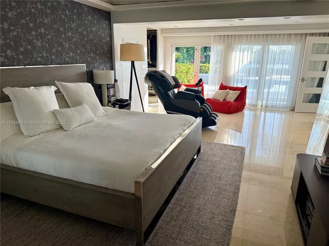 a bed sitting in a bedroom next to a window with lamp