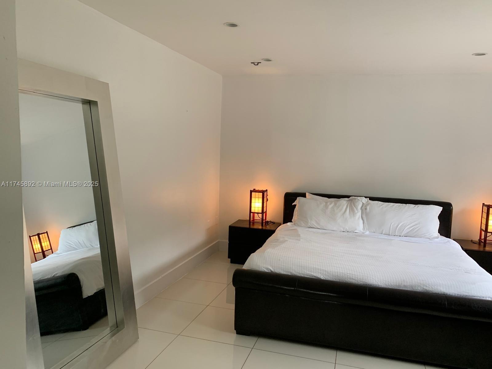 1670 Daytonia Road Miami Beach, FL 33141 - Photo 23 of 24 a room with a bed and a lamp on table