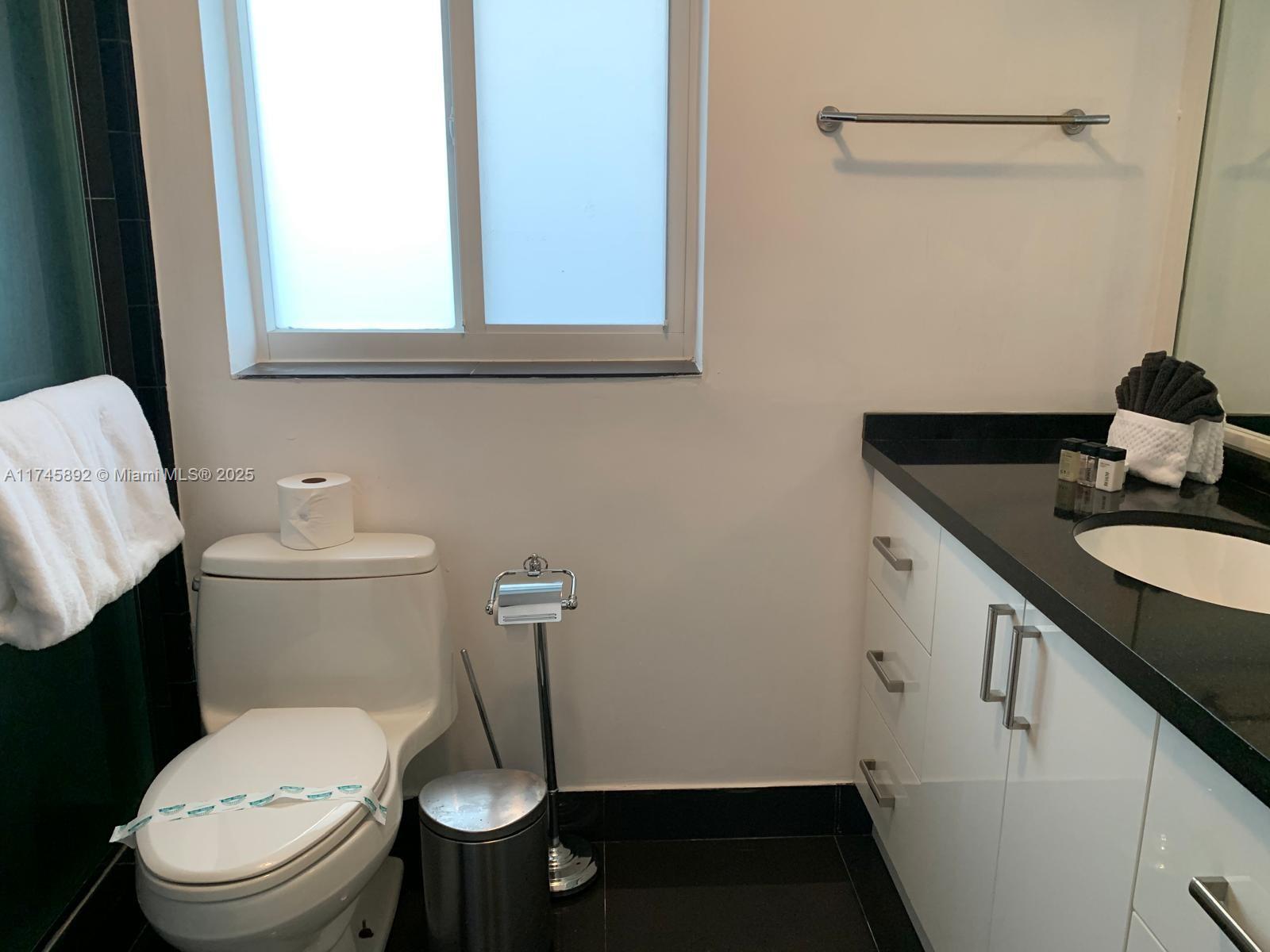 1670 Daytonia Road Miami Beach, FL 33141 - Photo 24 of 24 a bathroom with a granite countertop toilet sink and mirror