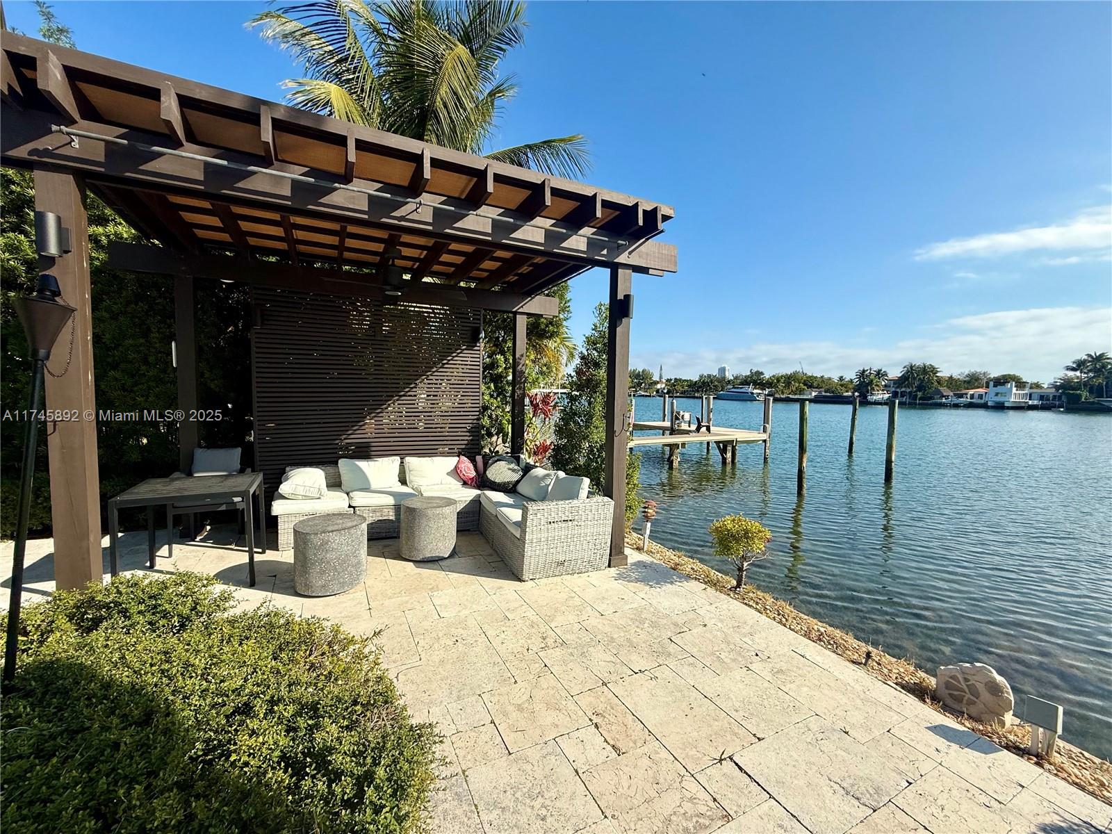 1670 Daytonia Road Miami Beach, FL 33141 - Photo 5 of 24 a view of a lake with tables and chairs under an umbrella