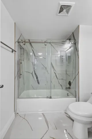 a bathroom with a toilet and a shower