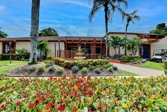 a view of a house with a yard and potted plants