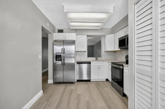 a kitchen with stainless steel appliances granite countertop a refrigerator and a stove
