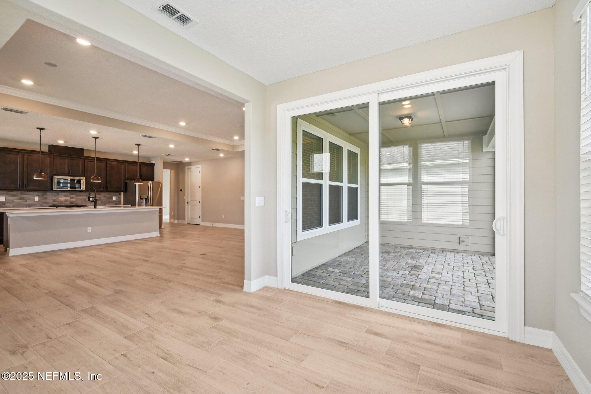 729 Continuum Loop Yulee, FL 32097 - Photo 13 of 31 a view of a hallway with wooden floor and living room