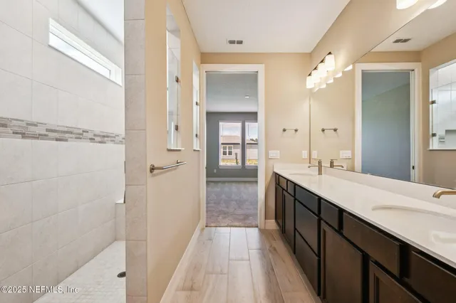 a bathroom with a double vanity sink and mirror