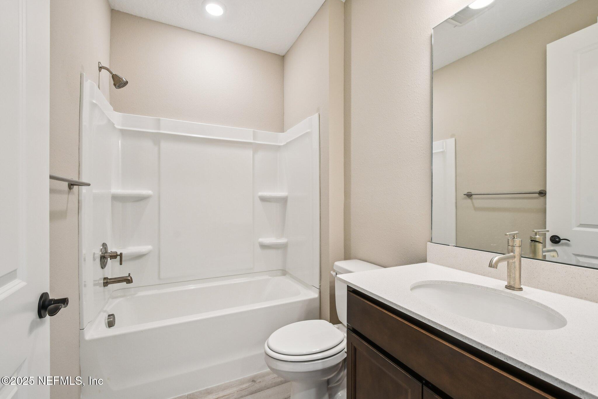 729 Continuum Loop Yulee, FL 32097 - Photo 23 of 31 a bathroom with a sink a toilet and a mirror