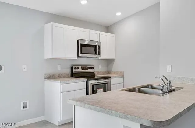 a kitchen with a sink a stove and microwave