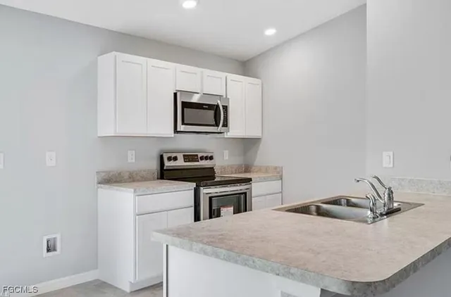 a kitchen with a sink a stove and microwave