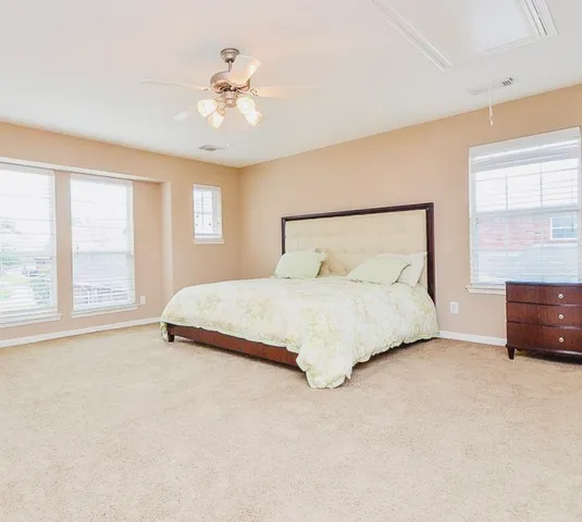 a bedroom with a large bed and a chandelier