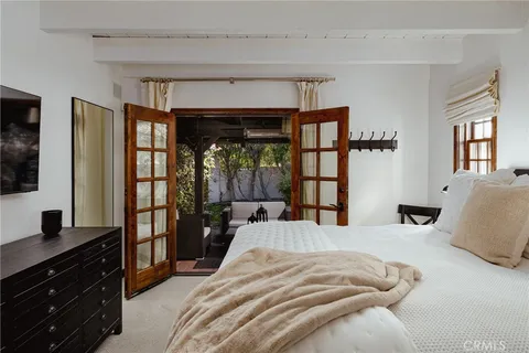 a bedroom with a bed and a flat tv screen on dresser