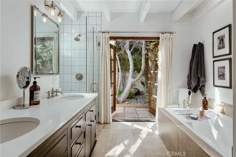 a bathroom with double vanity sink a mirror and a shower