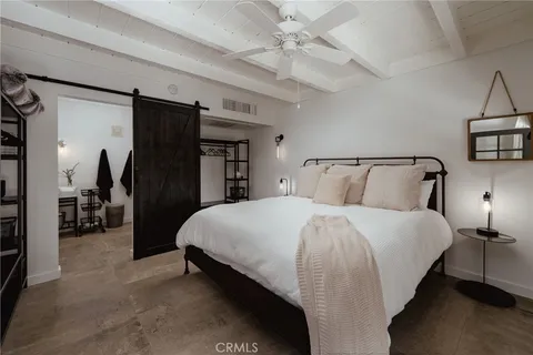 a large bed sitting in a bedroom next to a cabinet and a chandelier