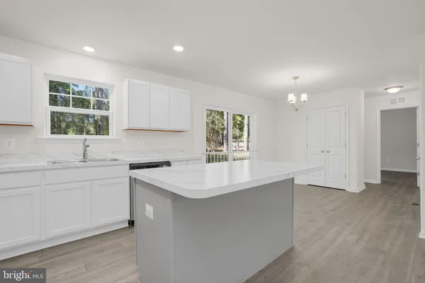 a kitchen with granite countertop white cabinets stainless steel appliances and a sink