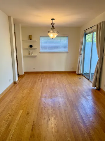 an empty room with wooden floor and a window