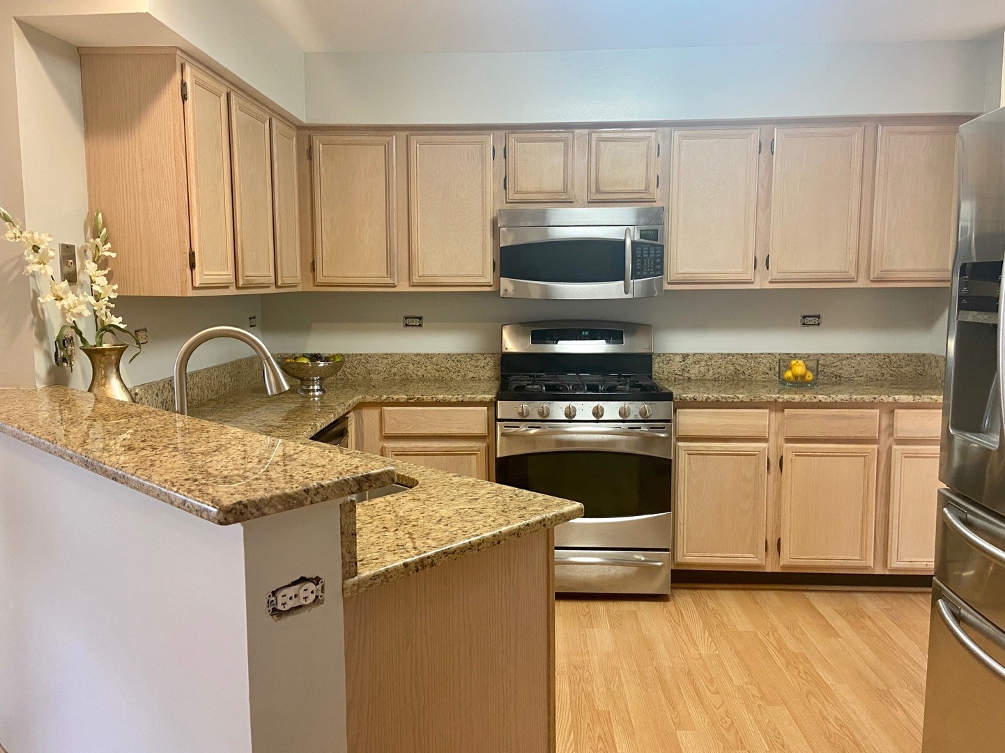 1198 Bristol Lane Buffalo Grove, IL 60089 - Photo 2 of 24 a kitchen with granite countertop a sink a stove top oven and cabinetry