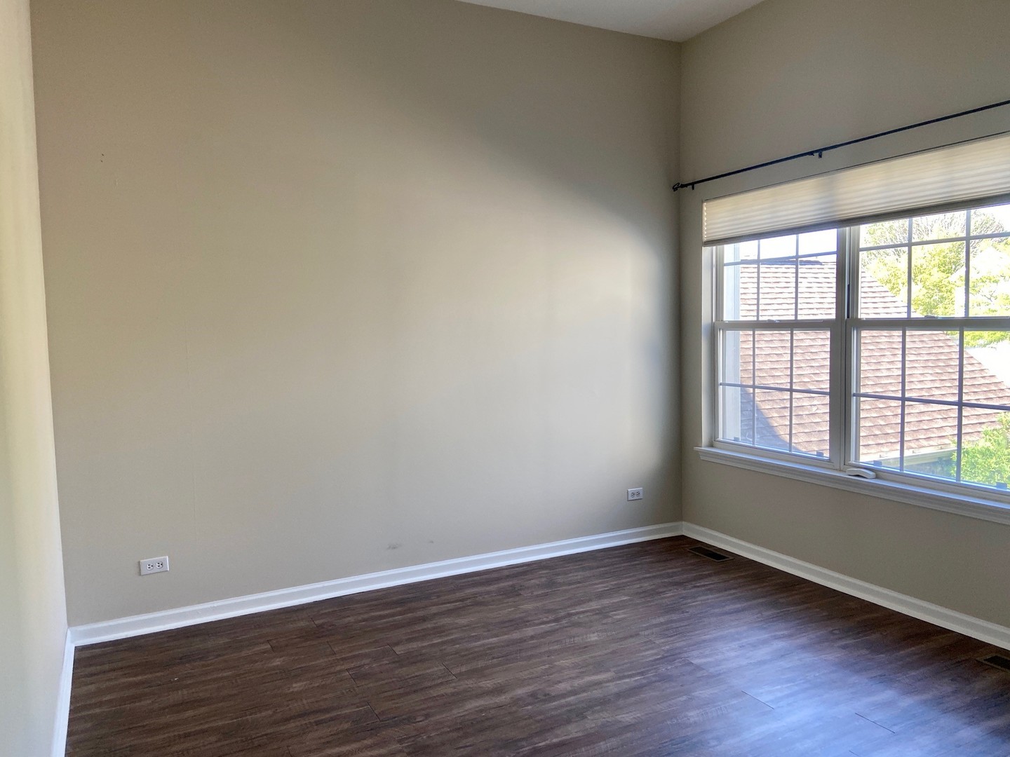 1198 Bristol Lane Buffalo Grove, IL 60089 - Photo 21 of 24 a view of an empty room with wooden floor and a window