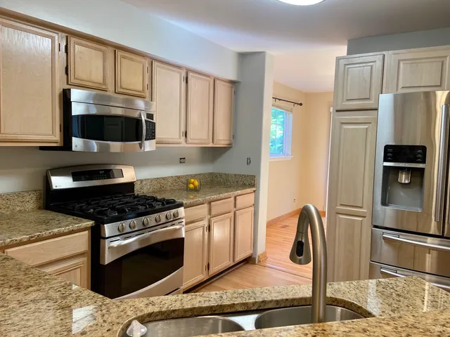 a kitchen with stainless steel appliances granite countertop a stove a refrigerator and a microwave