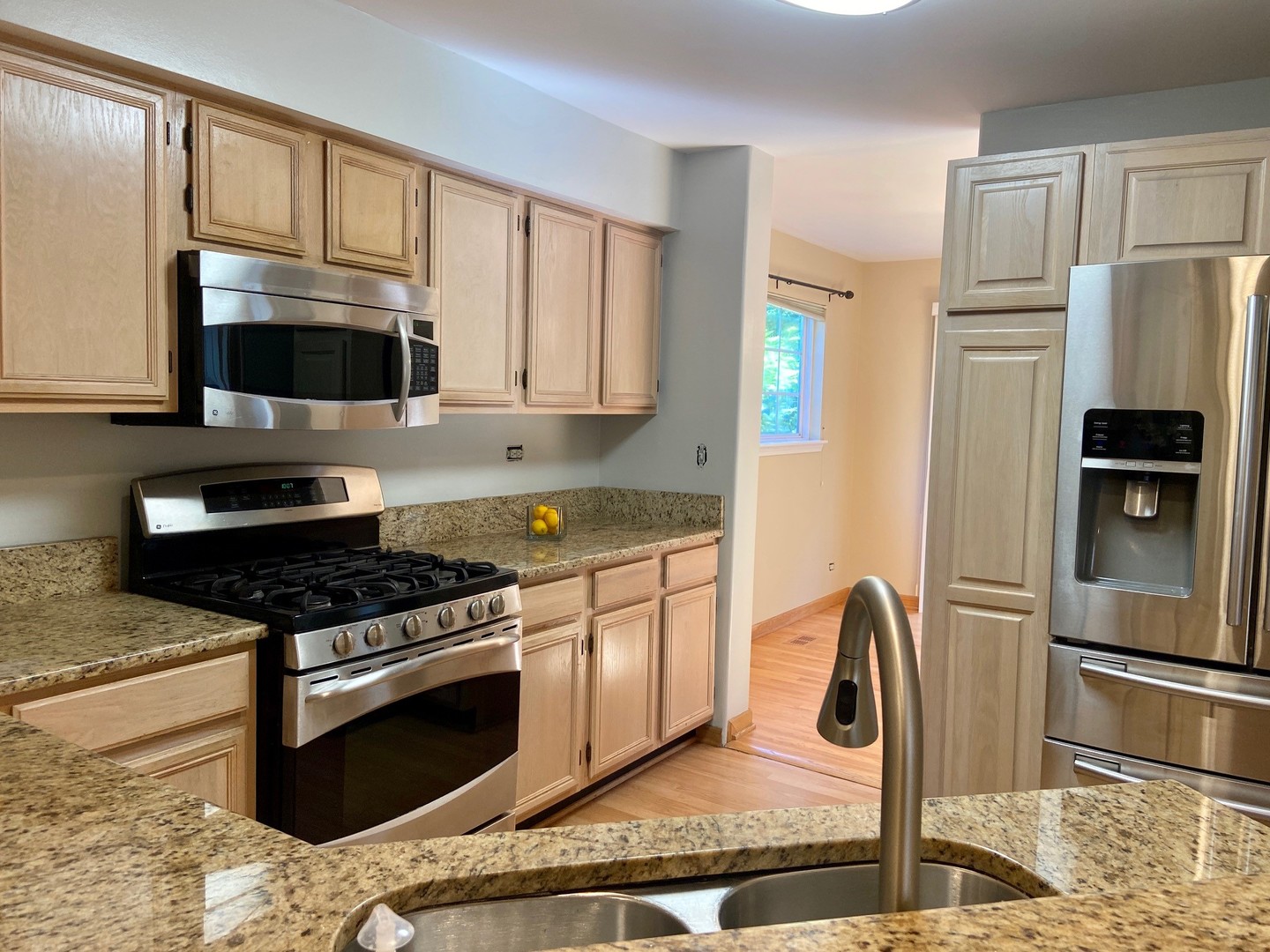 1198 Bristol Lane Buffalo Grove, IL 60089 - Photo 3 of 24 a kitchen with stainless steel appliances granite countertop a stove a refrigerator and a microwave