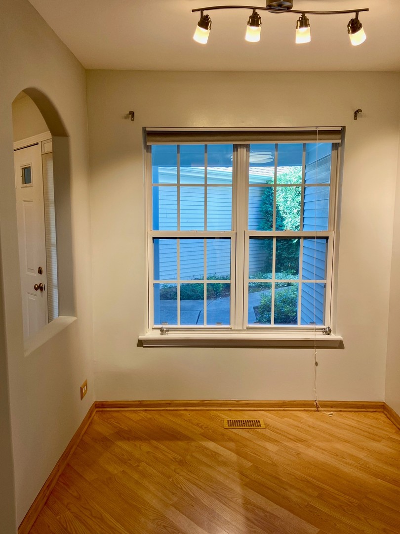 1198 Bristol Lane Buffalo Grove, IL 60089 - Photo 8 of 24 a view of an empty room with wooden floor and a window