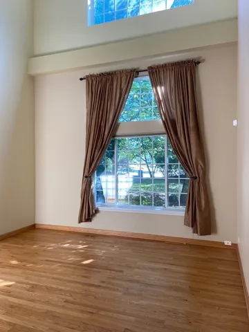 a view of a room with wooden floor and a window