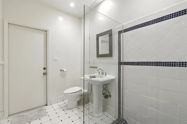 a bathroom with a sink a toilet and shower