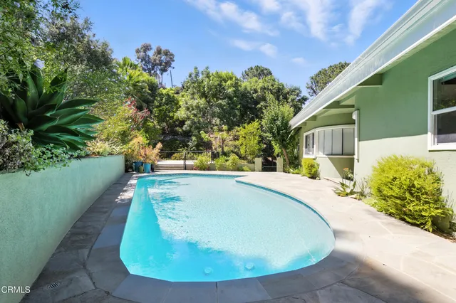 a view of house with patio and a garden