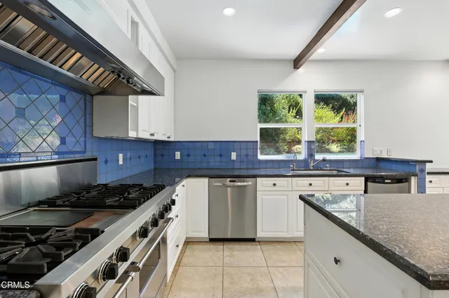 a kitchen with a sink stove top oven and cabinets