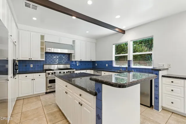 a kitchen with granite countertop a sink stainless steel appliances and cabinets