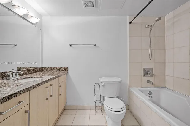 a bathroom with a granite countertop toilet a sink and a bathtub
