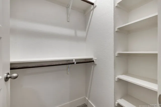 a view of a hallway with wooden floor and a potted plant