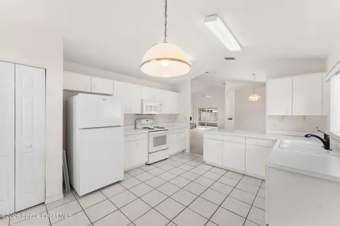 a kitchen with white cabinets and white appliances