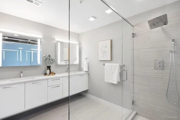 a bathroom with a double vanity sink a mirror and shower