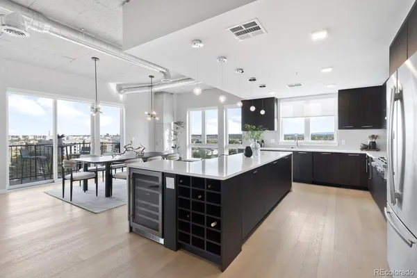 a large kitchen with a large counter top space a sink stainless steel appliances and cabinets