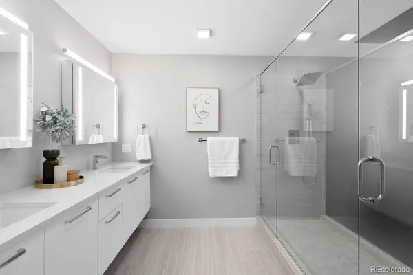 a bathroom with a double vanity sink a toilet and shower