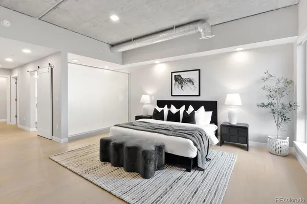 a spacious bedroom with a large bed and a chandelier