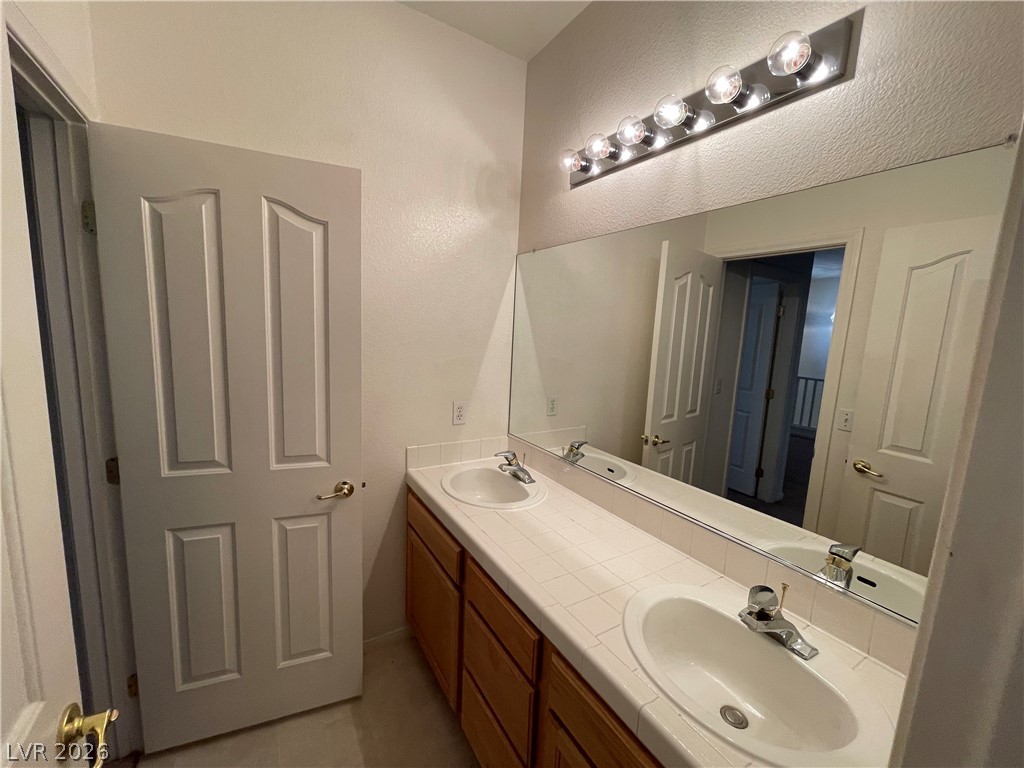 105 Parker Ranch Drive Henderson, NV 89012 - Photo 6 of 12 This bathroom features a double vanity and an expansive mirror.