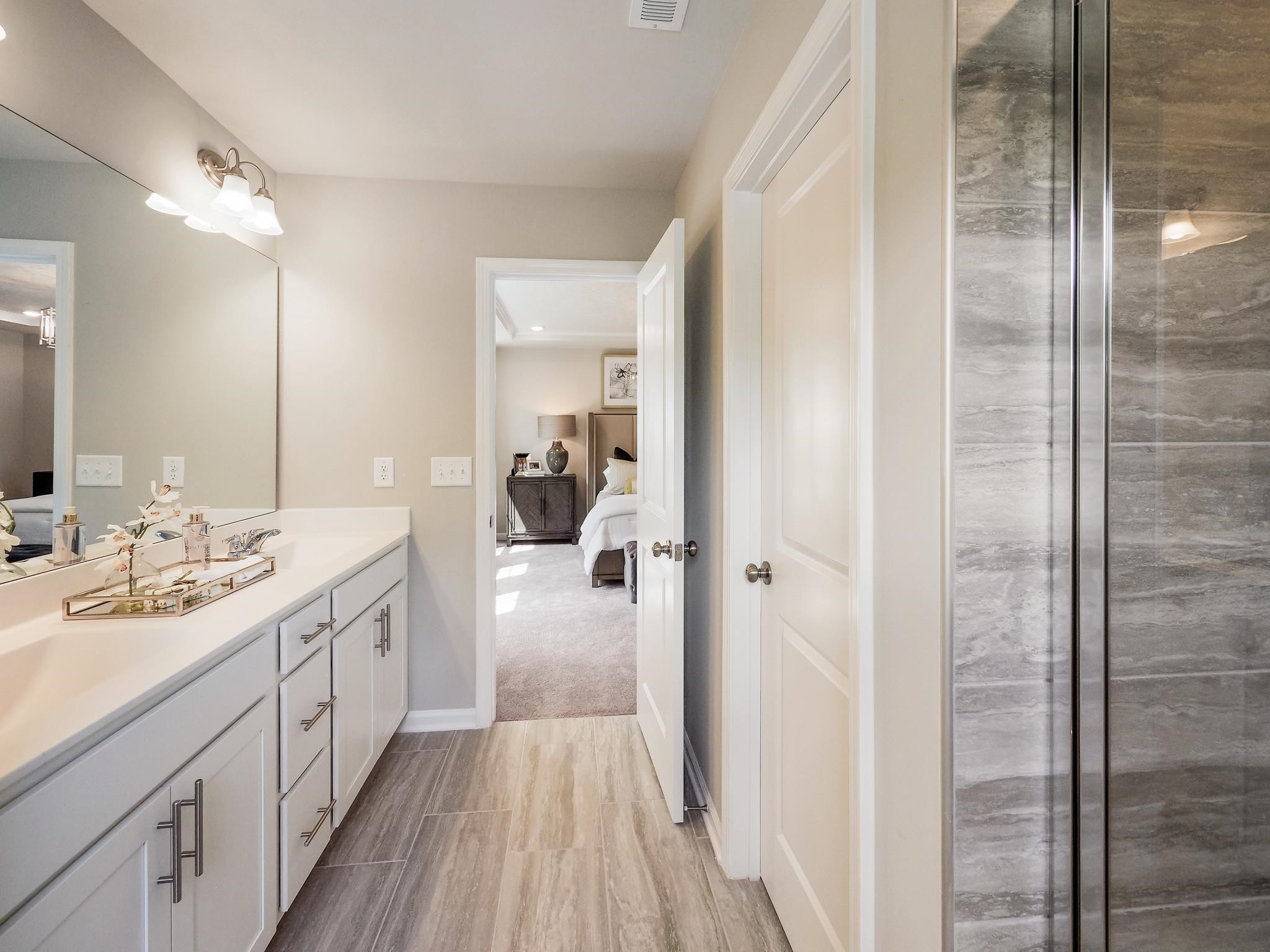 104 Sagebrook Drive, Unit 589 CHADWICK F Raleigh, NC 27610 - Photo 14 of 24 a spacious bathroom with a double vanity sink a mirror and shower