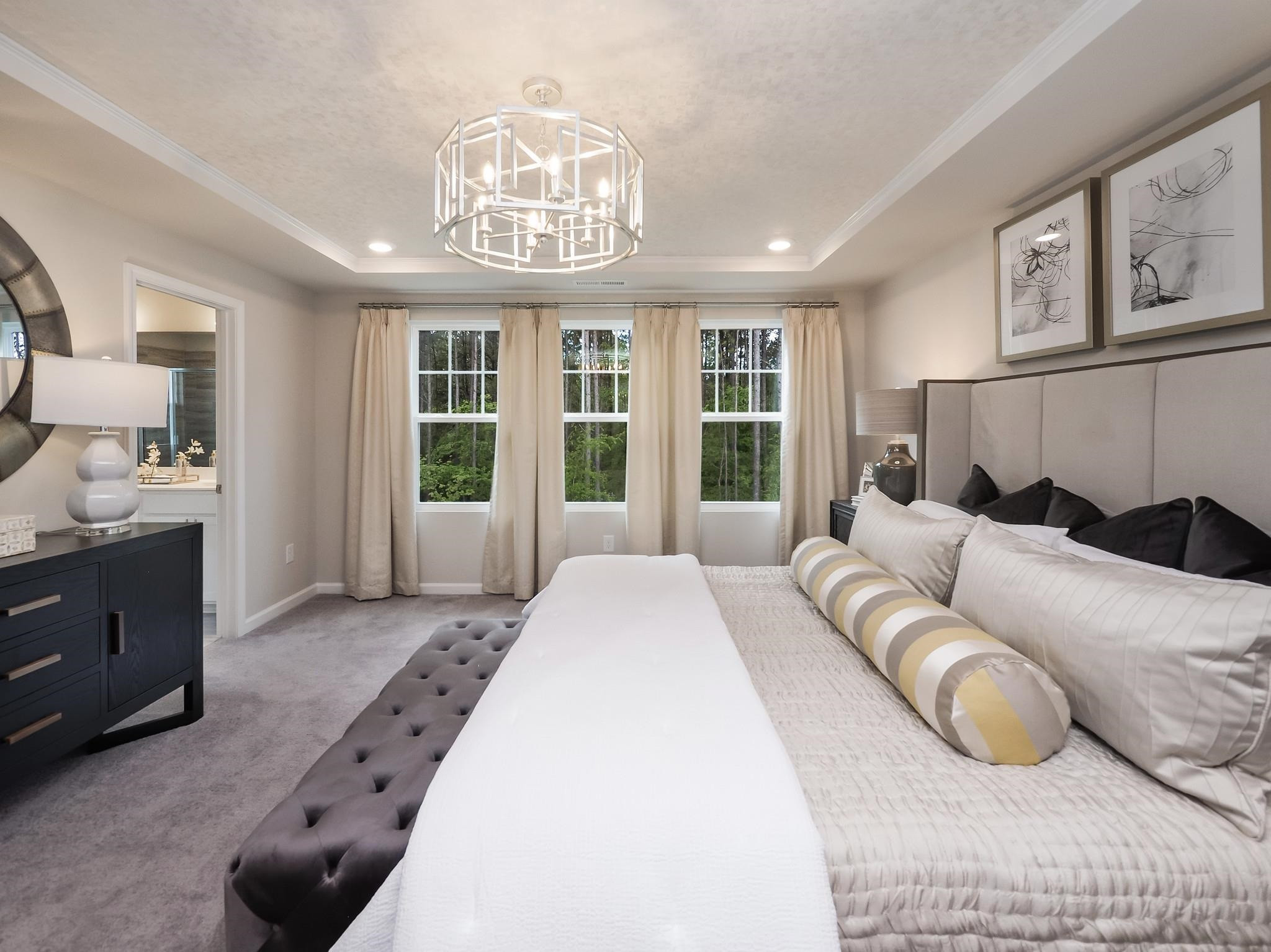 104 Sagebrook Drive, Unit 589 CHADWICK F Raleigh, NC 27610 - Photo 18 of 24 a spacious bedroom with a bed a chandelier and a large window
