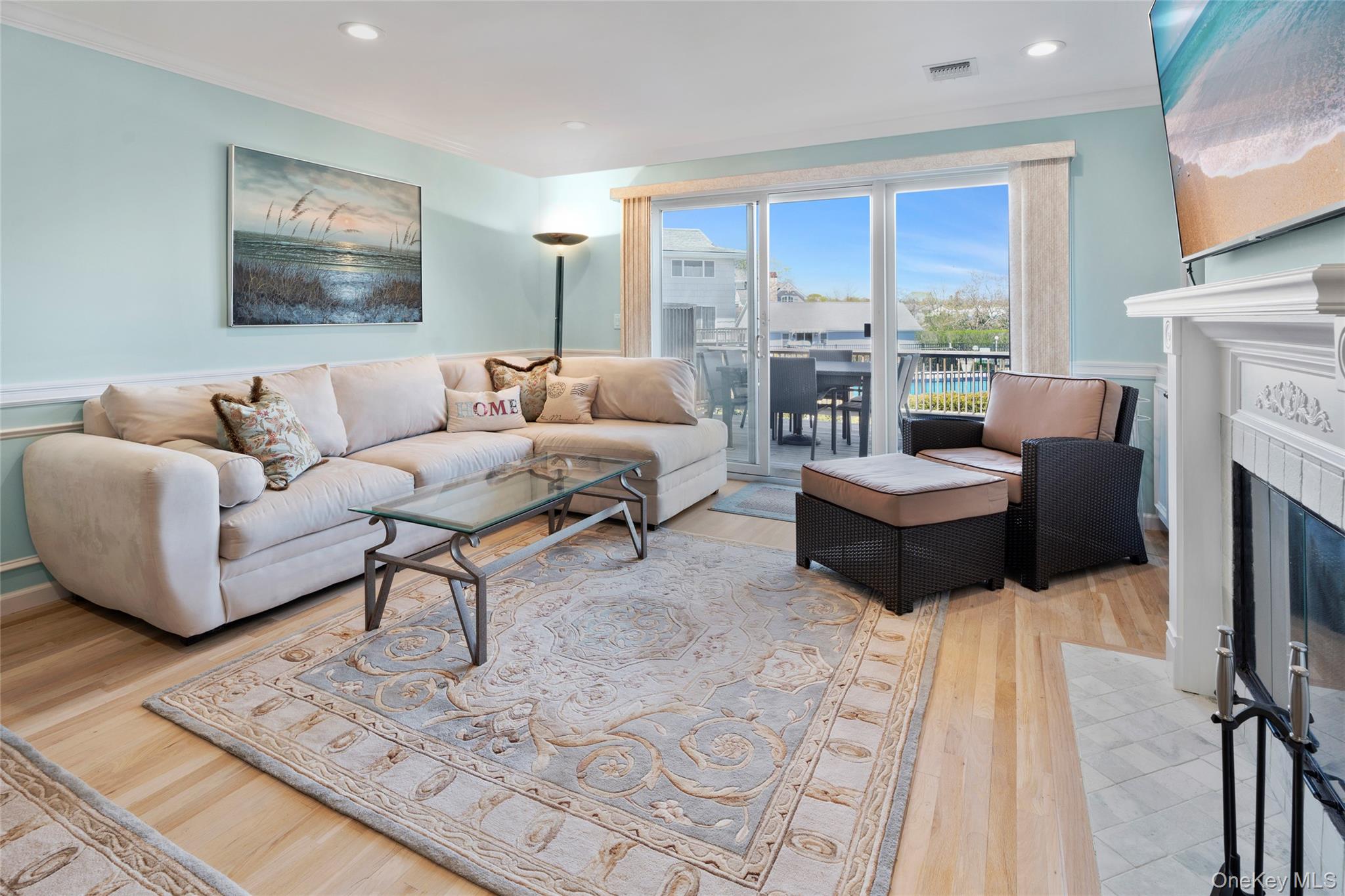 3012 Mitchell Road, Unit 3012 Westhampton Beach, NY 11978 - Photo 2 of 19 a living room with fireplace furniture and a large window