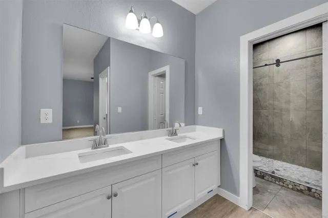 a bathroom with double sink and a mirror